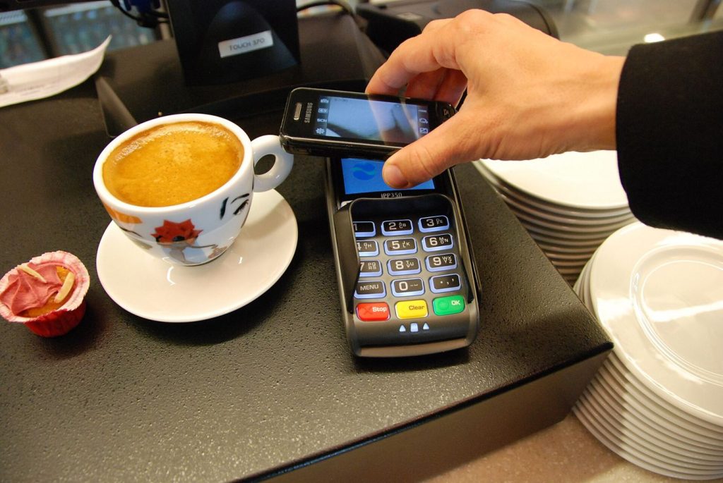 Digital Payments Are Rewriting How the World Moves Money Every Day A person paying with a smartphone using a contactless digital payment.